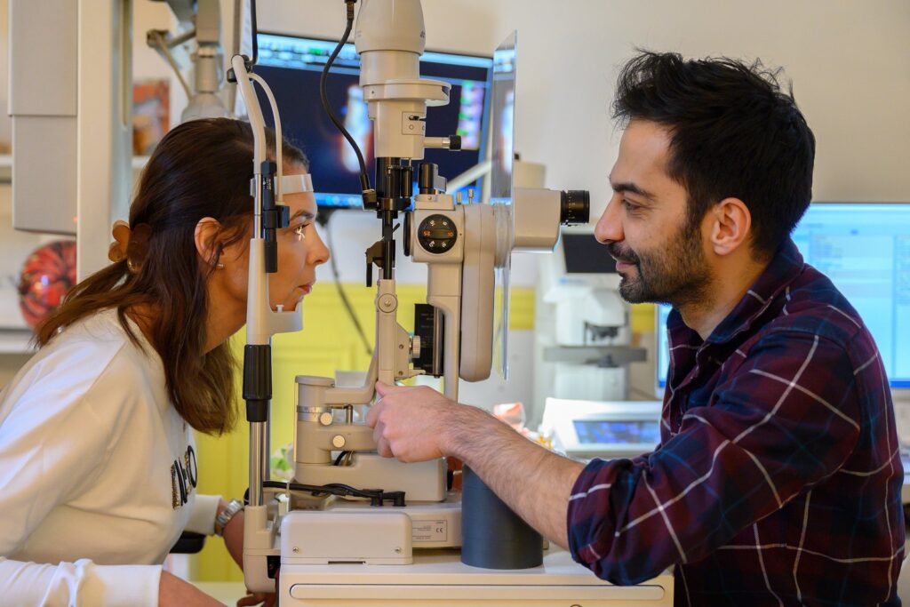 Le Dr Alexandre Omidi examine une patiente à la lampe à fente