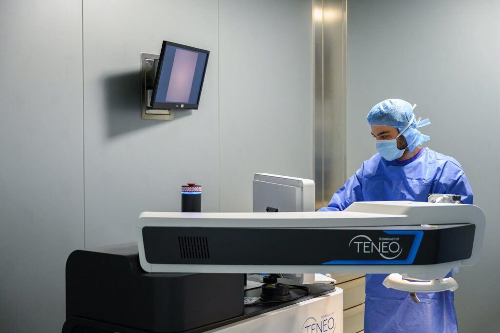 Le Dr Alexandre Omidi en tenue de bloc devant le laser Excimer
