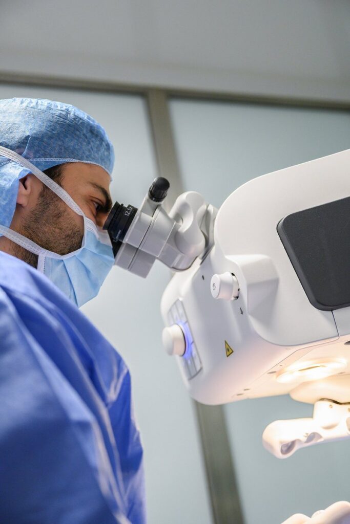 Le Dr Alexandre Omidi au microscope opératoire pendant une chirurgie de la myopie